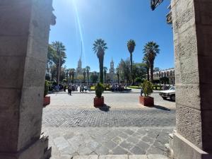 a city square with palm trees and a building at Maison plaza in Arequipa
