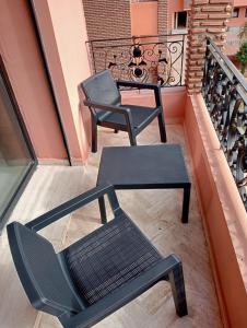 two chairs and a table on a balcony at Babylone Marrakech in Marrakech