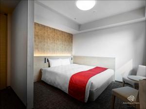 1 dormitorio con 1 cama grande con manta roja en Daiwa Roynet Hotel Osaka-Uehonmachi, en Osaka