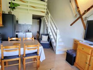 a dining room with a table and chairs and a staircase at Duplex 4 pers - 1 ch - Centre station - Balcon Sud - Wifi - Parking - FR-1-393-114 in Saint-Michel-de-Chaillol