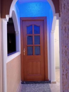 a wooden door in a hallway with a blue ceiling at Babylone Marrakech in Marrakech