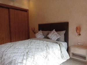 a bedroom with a large bed with white sheets and pillows at Babylone Marrakech in Marrakech