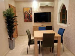 a dining room with a wooden table and chairs at Babylone Marrakech in Marrakech