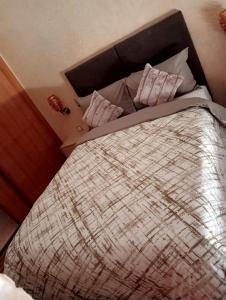 a bed with a comforter and pillows on it at Babylone Marrakech in Marrakech