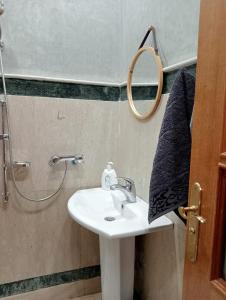 a bathroom with a sink and a mirror at Babylone Marrakech in Marrakech