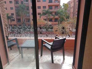 a balcony with a table and chairs on a balcony at Babylone Marrakech in Marrakech