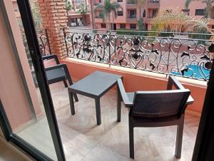 a table and two chairs on a balcony with a view at Babylone Marrakech in Marrakech
