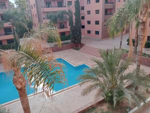 an overhead view of a swimming pool with palm trees at Babylone Marrakech in Marrakech