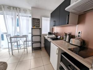 Una cocina con gabinetes negros y encimera. en Vitrail YourHostHelper, en Bayona