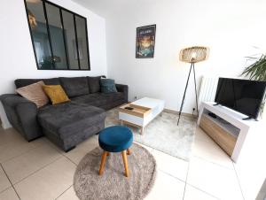 Una sala de estar con un sofá y un televisor. en Vitrail YourHostHelper, en Bayona