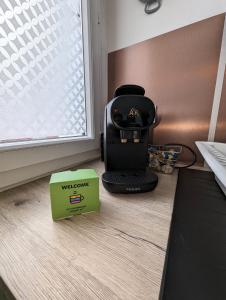 Una cafetera colocada en el suelo junto a una ventana. en Vitrail YourHostHelper, en Bayona 2 fotos más