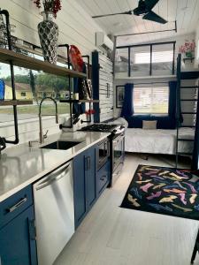 uma cozinha com um lavatório e um sofá em Modern, pet friendly tiny house, No extra fees! em Clermont