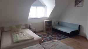 ブルガウにあるPrivatzimmerのベッド1台とソファが備わる小さな客室です。