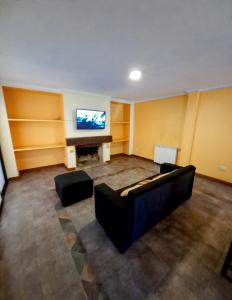 een woonkamer met een bank en een flatscreen-tv bij Casa Avellaneda in Mendoza