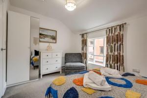 a bedroom with a bed and a chair and a window at Central Belfast Apartments Queen's Lofts in Belfast +21 photos