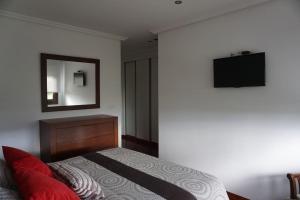 BustoにあるCasa Playa de Bozoのドレッサーと鏡付きのベッドのある寝室