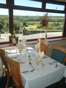 a table with a white table cloth and vases on it at Bowood Park Hotel in Camelford