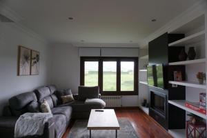 a living room with a couch and a table at Casa Playa de Bozo in Busto