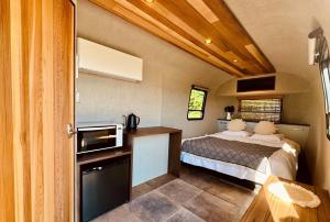 ein kleines Schlafzimmer mit einem Bett in einem Zimmer in der Unterkunft アイカフェファーム in Hokuto