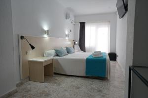 a bedroom with a bed and a desk and a window at Hotel Teide in El Arenal +37 photos