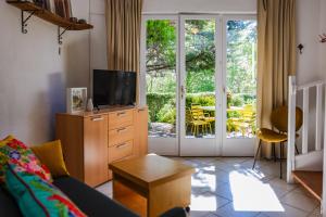 uma sala de estar com um sofá e uma televisão em Les Hauts de Jeanvert - Le Chêne - Piscine - Gaillac em Gaillac