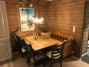 ein Esszimmer mit einem Holztisch und Stühlen in der Unterkunft Voss Resort Bavallstunet in Skulestadmo
