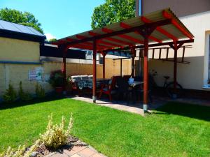 pergola ze stołem i krzesłami na dziedzińcu w obiekcie Luna Vendégház w Siófoku