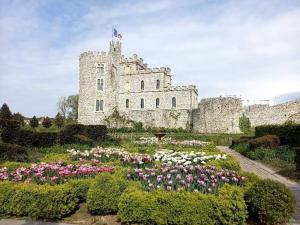 een kasteel met een tuin met bloemen ervoor bij Le Grand Chêne in Condette