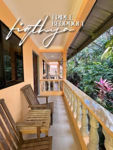 a porch with two wooden chairs on a house at Fiqthya Chalet & Cafe in Tioman Island