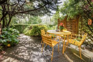 uma mesa e cadeiras num jardim com uma mesa e flores em Les Hauts de Jeanvert - Le Chêne - Piscine - Gaillac em Gaillac