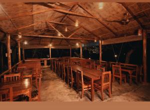 a dining room with wooden tables and chairs at PRISTINE BEACH RESORT in Diglipur