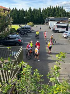 eine Gruppe von Menschen, die auf einem Parkplatz Fahrrad fahren in der Unterkunft Abel Hôtel in Langeac
