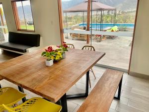 ein Esszimmer mit einem Holztisch und gelben Stühlen in der Unterkunft Acogedoras Casas de campo en Cieneguilla in Cieneguilla