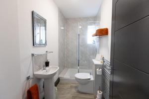 a bathroom with a toilet and a sink and a shower at Victoria Apartments in Skegness