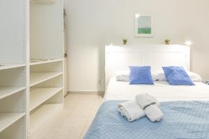 een slaapkamer met een bed met blauwe en witte kussens bij Apartamento en Tossa de Mar a 3 min de la playa in Tossa de Mar