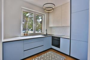a kitchen with white cabinets and a window at Luxury Apartment Blue in Ivan Dolac