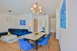 a living room with a dining table and blue chairs at Luxury Apartment Blue in Ivan Dolac