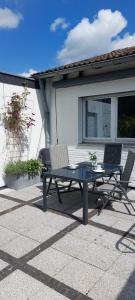 a picnic table and two chairs on a patio at Helle Ferienwohnung mit Garten und Terrasse, direkt am Waldrand gelegen in Herzogenrath