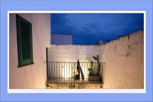 a building with a balcony with a potted plant on it at Petrarussa Dimora Storica in Morciano di Leuca