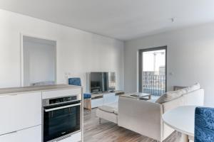 eine Küche und ein Wohnzimmer mit einem Sofa und einem Tisch in der Unterkunft GuestReady - Charming getaway with a terrace in Lyon