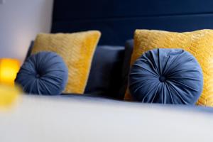 two blue pillows on a bed with yellow pillows at Victoria Apartments in Skegness