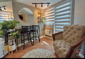 ein Wohnzimmer mit einem Tisch, Stühlen und einem Spiegel in der Unterkunft Azure North Amirah’s Place in San Fernando
