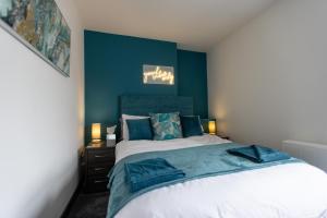a bedroom with a large bed with blue walls at Victoria Apartments in Skegness