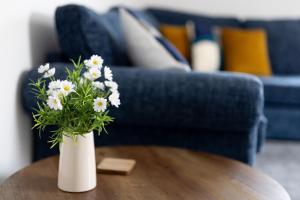 a white vase with white flowers on a table at Victoria Apartments in Skegness