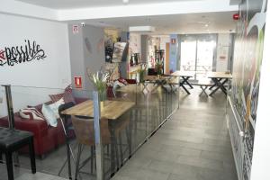New Art Hostel - Albergue Juvenil في بالما دي ميورقة: مطعم فيه طاولات وكراسي في الغرفة