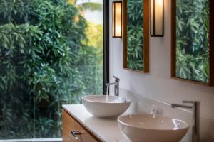 a bathroom with two sinks and a large window at Penthouse Luxueux avec Piscines, Vues Mer et Montagne in Rivière Noire +23 photos