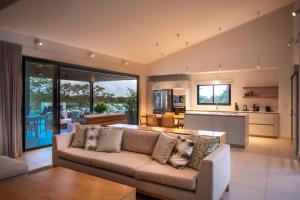 a living room with a couch and a kitchen at Penthouse Luxueux avec Piscines, Vues Mer et Montagne in Rivière Noire
