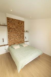 a bedroom with a bed and a brick wall at coté verdon 2 in Quinson