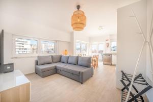 a living room with a couch and a kitchen at GuestReady - Sunny Retreat in Costa da Caparica in Costa da Caparica