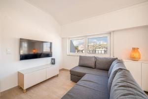 a living room with a couch and a tv at GuestReady - Sunny Retreat in Costa da Caparica in Costa da Caparica +22 photos
